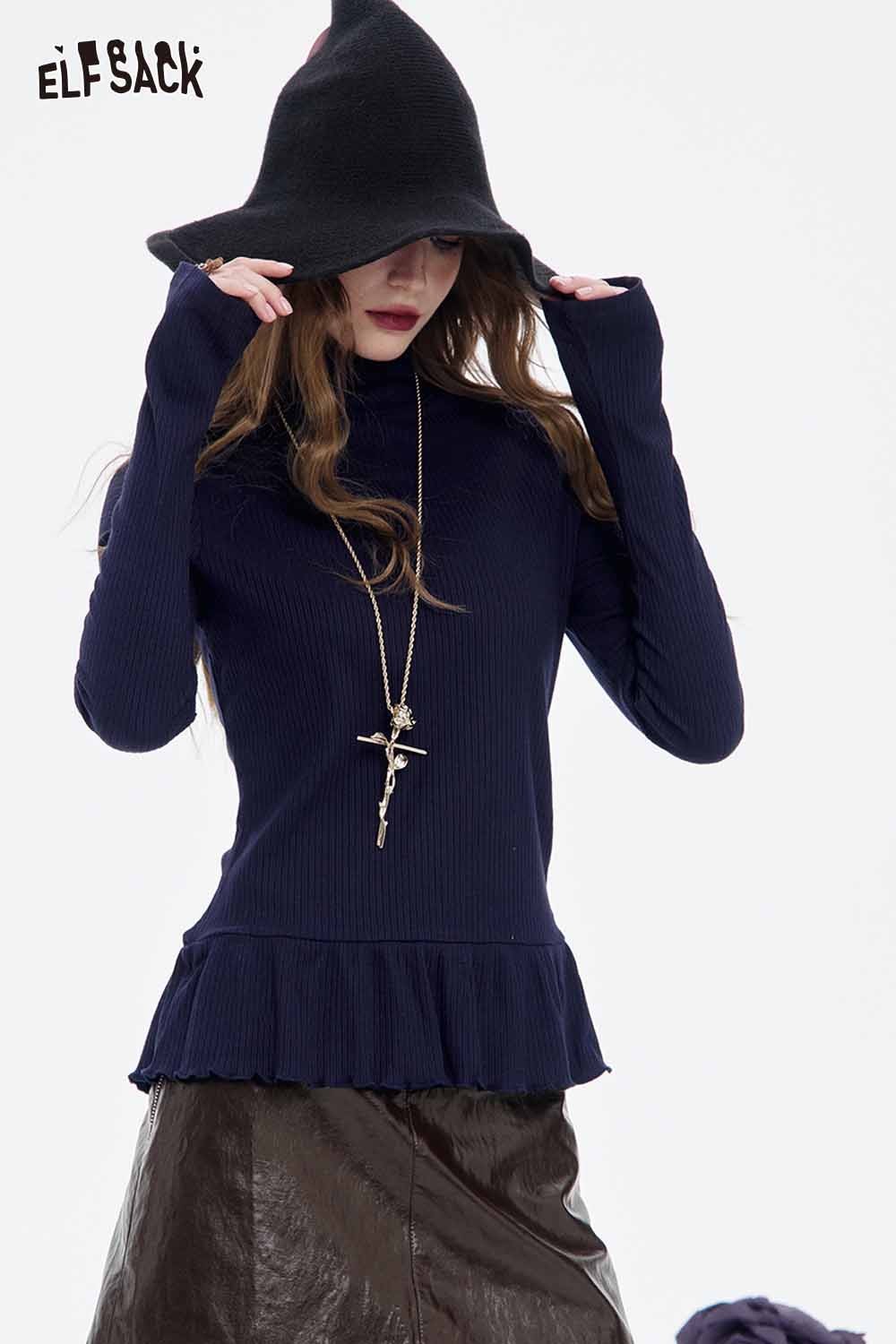 Stylish model wearing a navy top with a frilled bottom and a soft shiny leather skirt