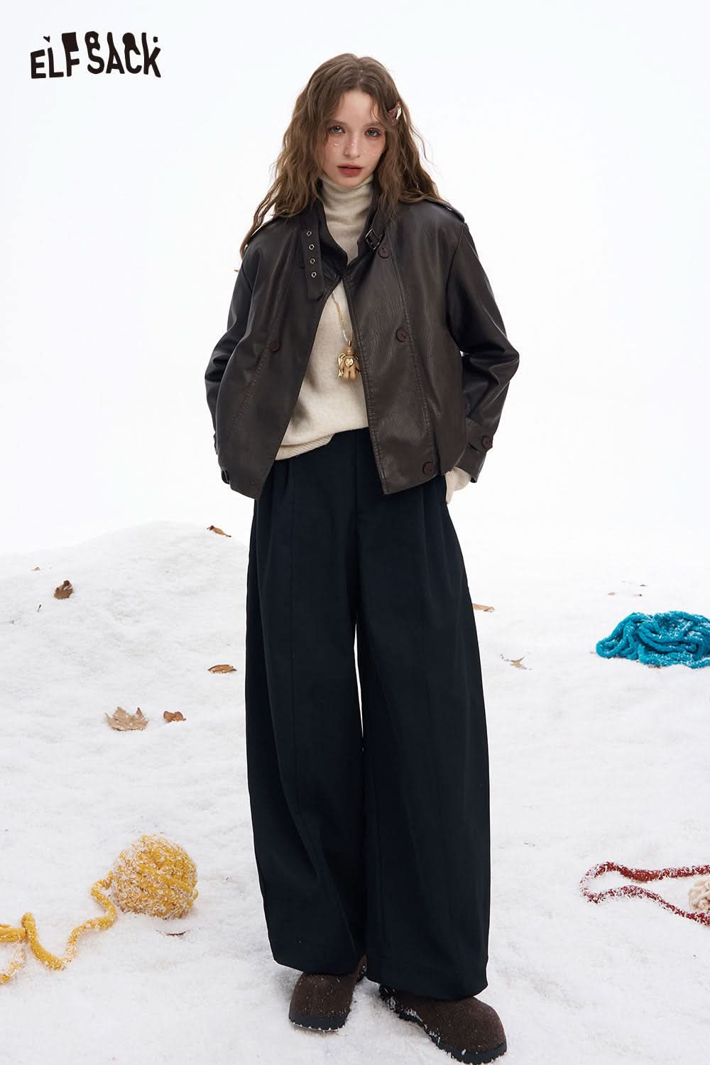 ELFSACK women's wide leg floor length pants in black, styled with a cozy sweater and jacket in a snowy setting.