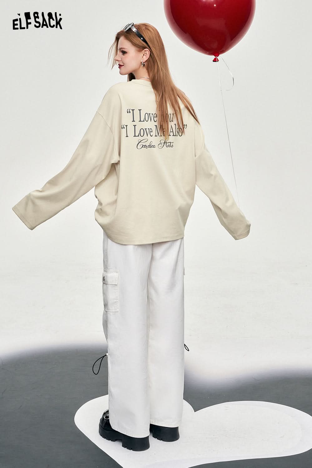 ELFSACK Y2K Alphabet Graphic beige oversized T-shirt with text print on back styled with white wide-leg pants
