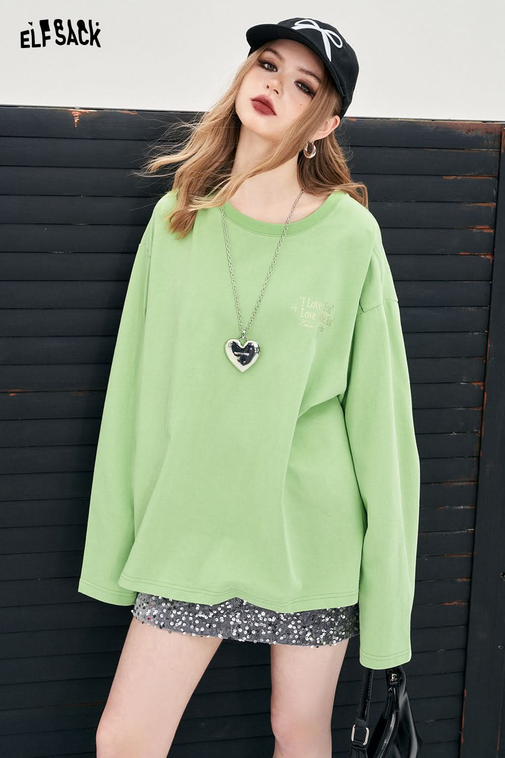 ELFSACK green oversized Y2K Alphabet Graphic t-shirt worn with black cap and silver heart necklace