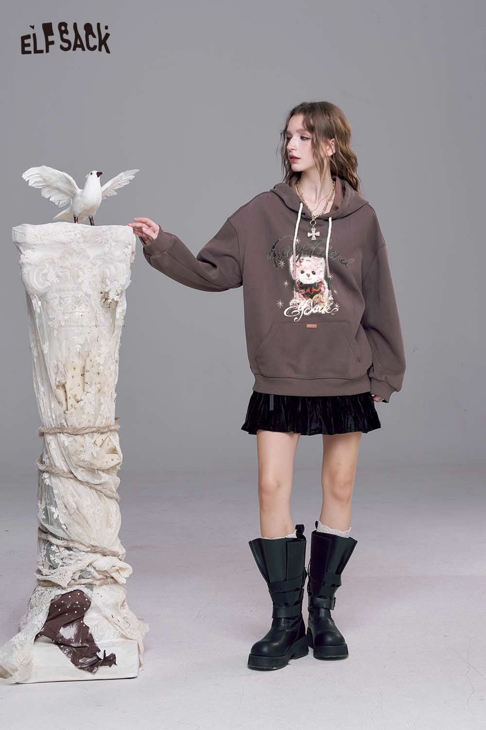 ELFSACK vintage cartoon graphic hoodie in brown with unique design, paired with a skirt and trendy boots