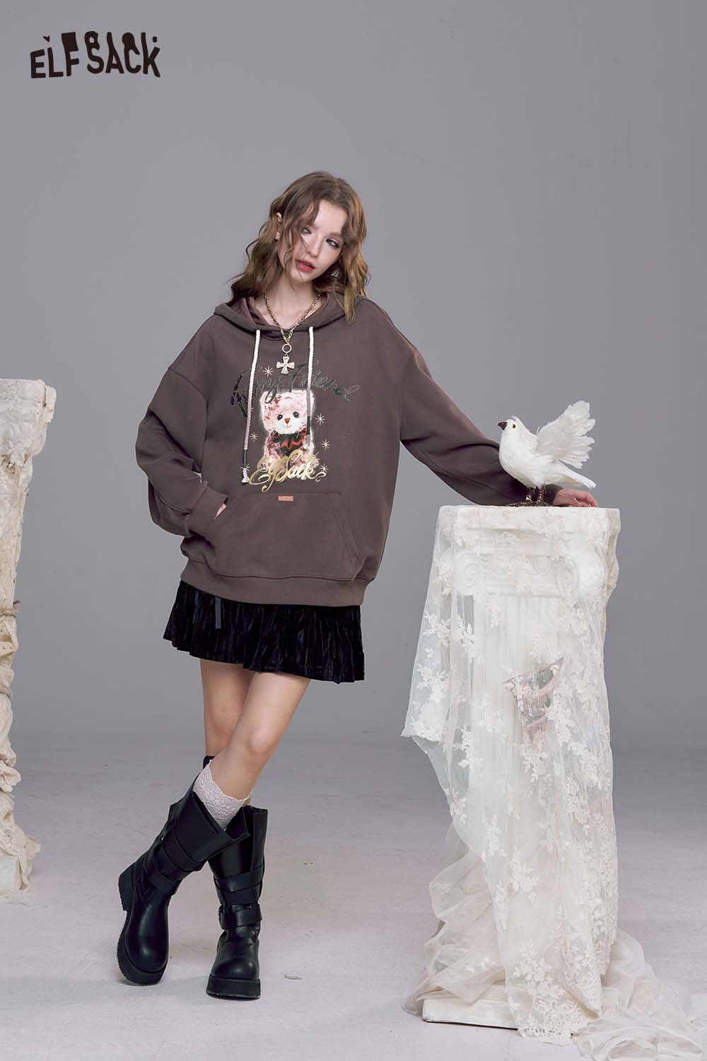 ELFSACK vintage cartoon graphic hoodie in brown with playful design, paired with a skirt and boots