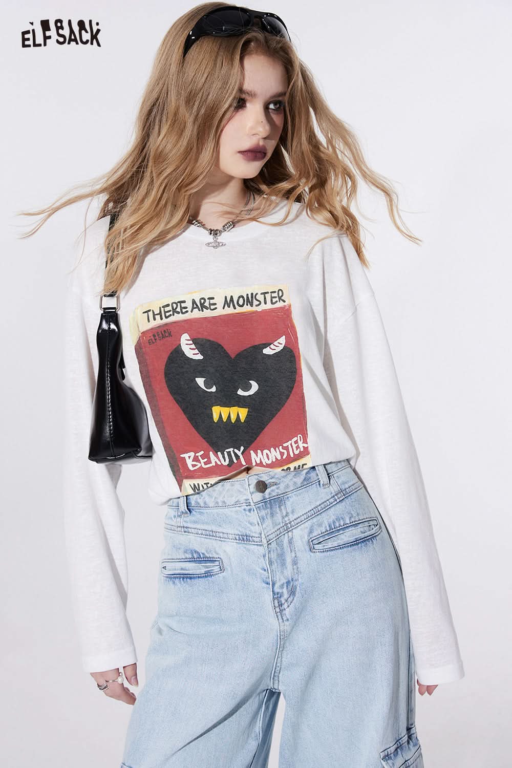 ELFSACK white long sleeve T-shirt with graphic print of a black heart monster and text