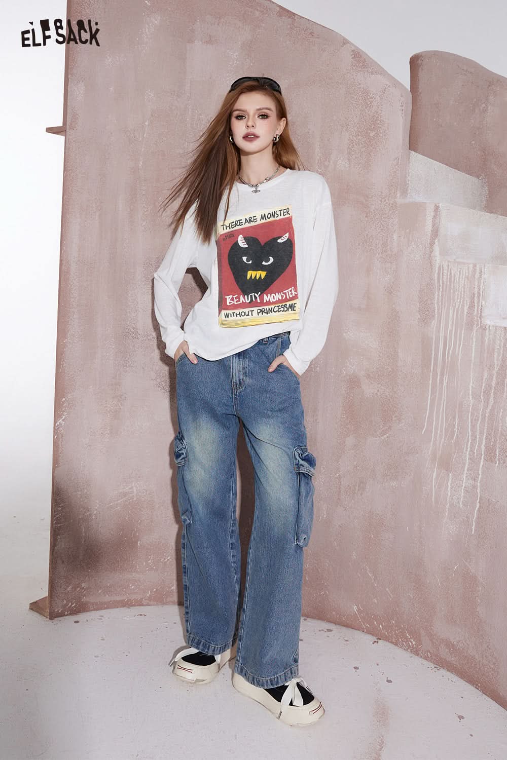ELFSACK white long sleeve t-shirt with graphic print of a black cat and text worn with blue cargo jeans