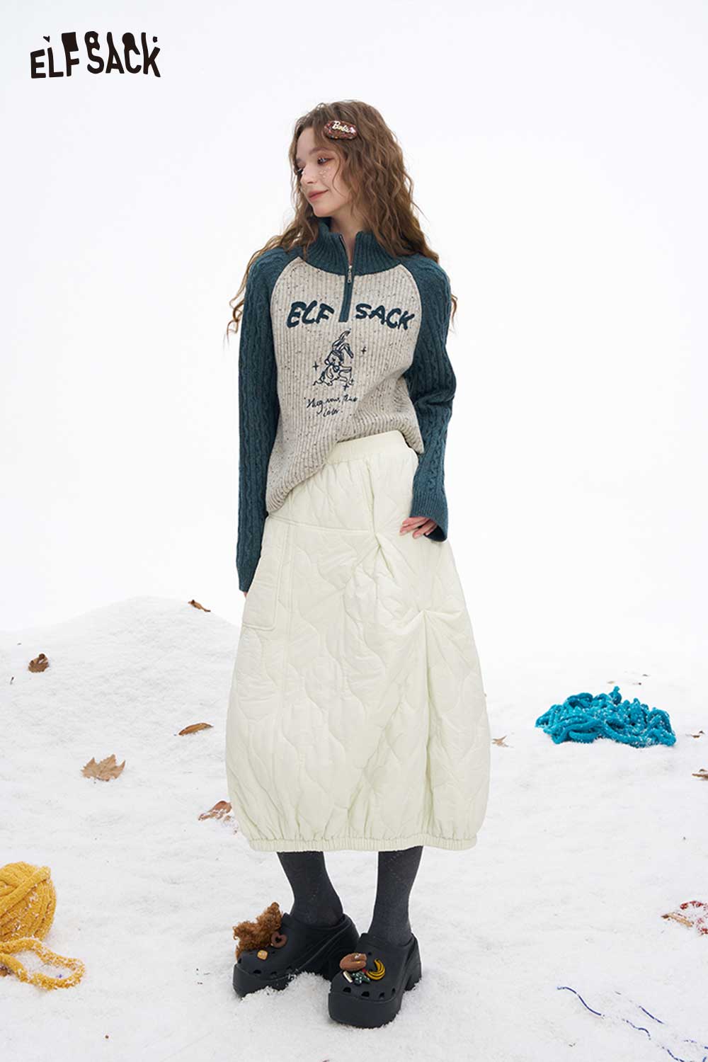 ELFSACK women's down half skirt in white with a cozy sweater for a stylish winter look