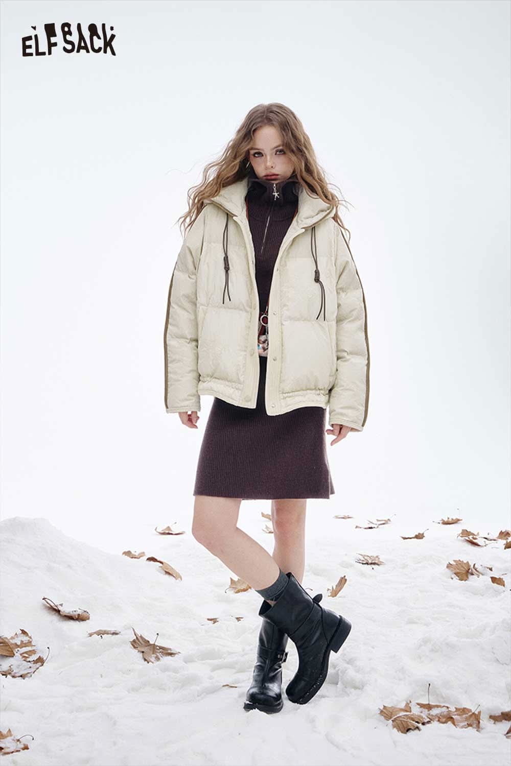 ELFSACK women's hooded down jacket in cream, styled with a burgundy dress and black boots in a snowy setting.