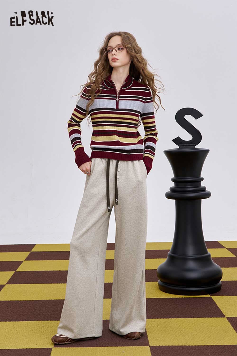 Women's loose drawstring pants in light beige paired with a stylish striped sweater for a comfortable look