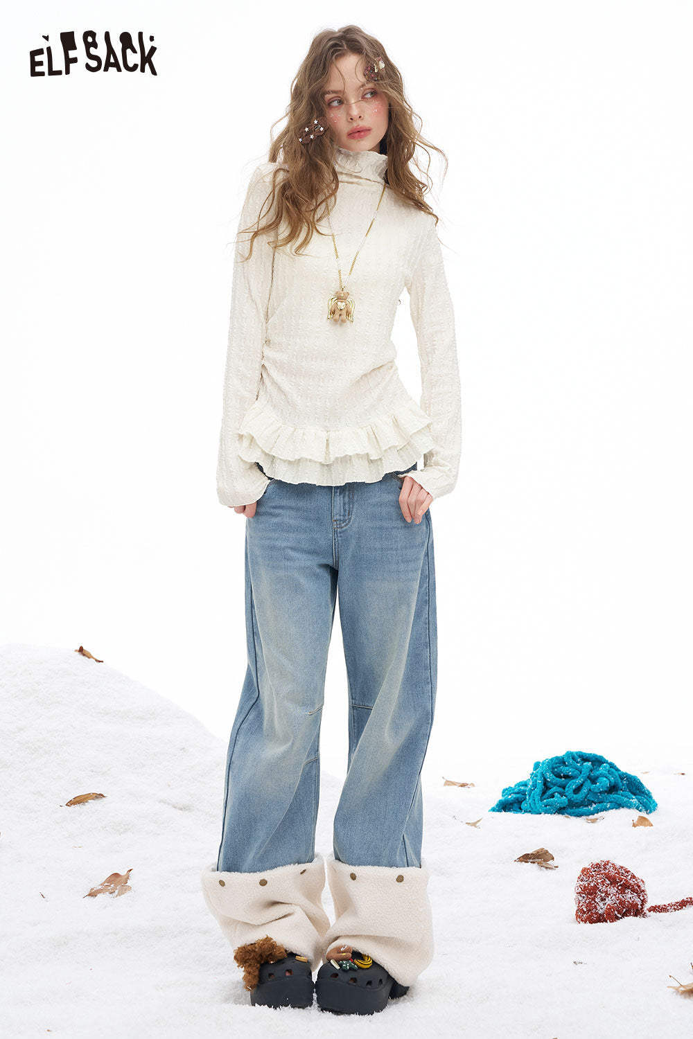 Trendy women's ruffle high neck t-shirt in cream with a flared hem, styled with relaxed denim jeans