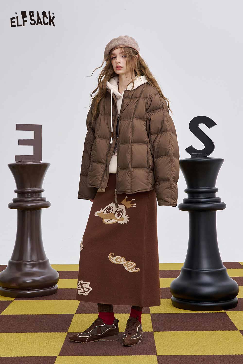 ELFSACK women's soft down jacket in brown, styled with a cozy outfit and chess pieces for a fashionable look