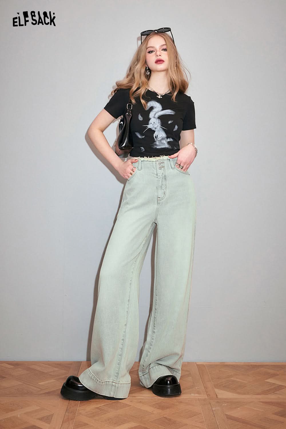 ELFSACK black Y2K Rabbit Print t-shirt worn by model with light washed wide-leg jeans and black shoes