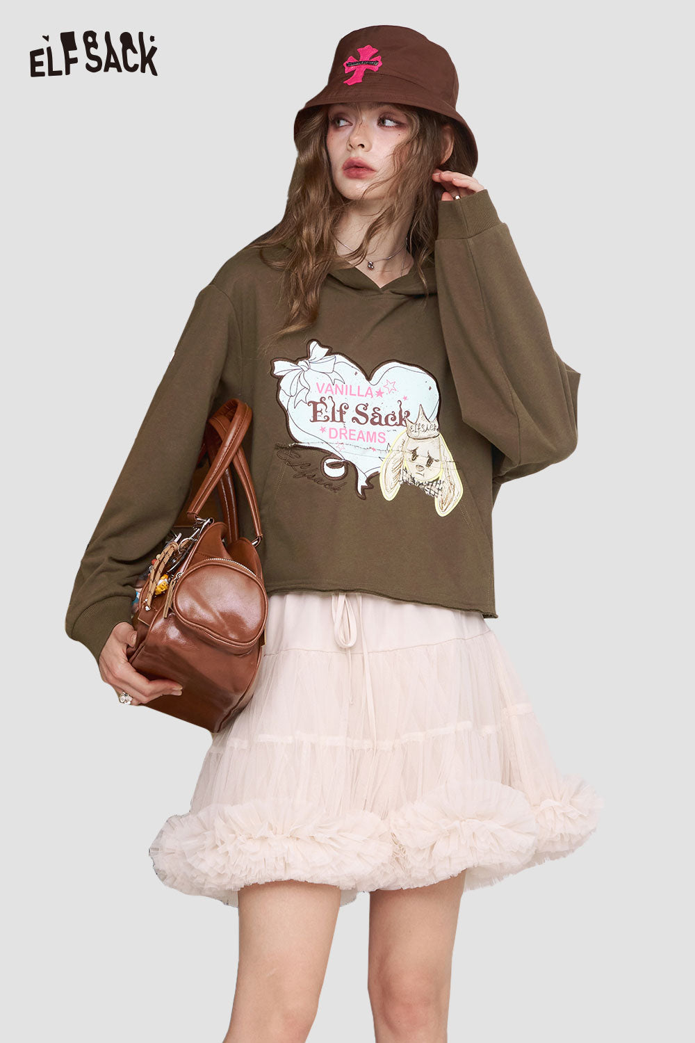 ELFSACK model wearing olive graphic American style print hoodie for women with tulle skirt brown bucket hat and leather bag