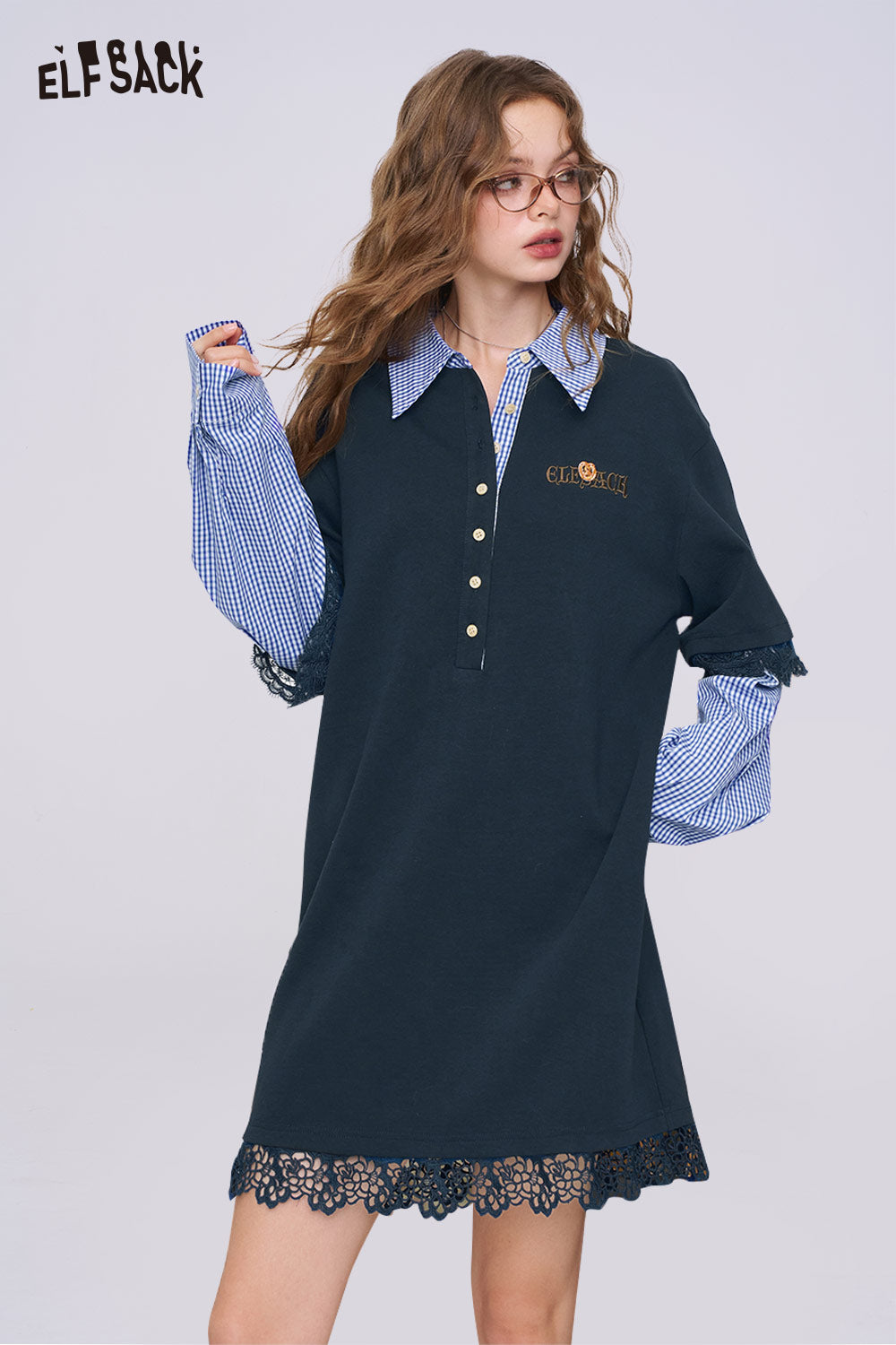 ELFSACK model wearing navy polo knit dress layered over blue gingham shirt with lace trim college style knit dress