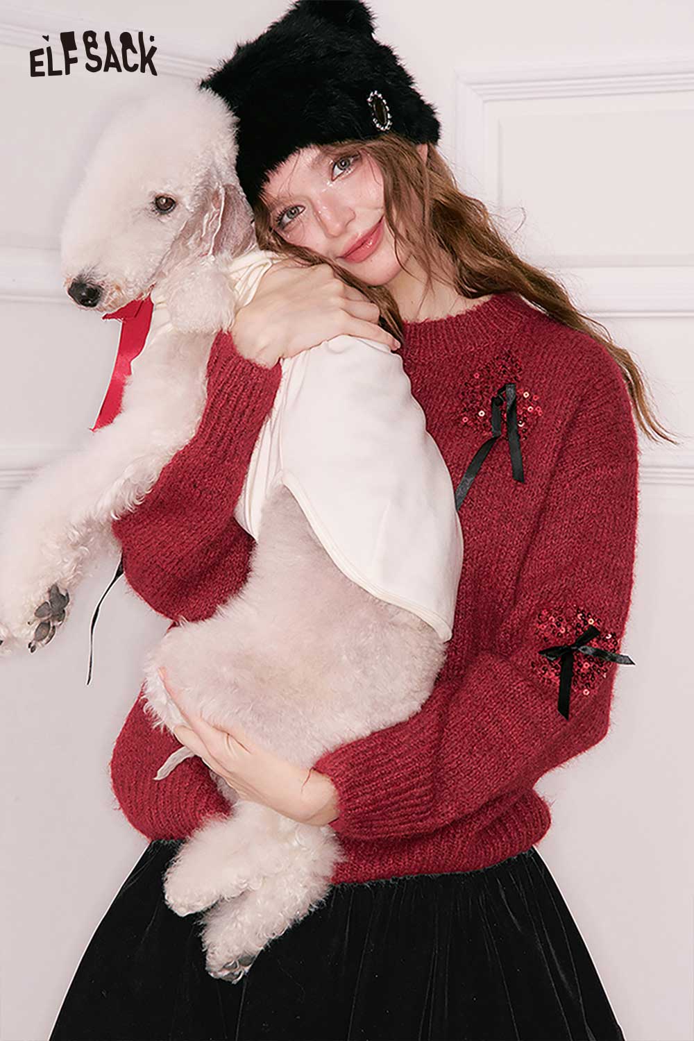 ELFSACK 3D bow embellished cropped sweater in red, worn by a model holding a white fluffy dog