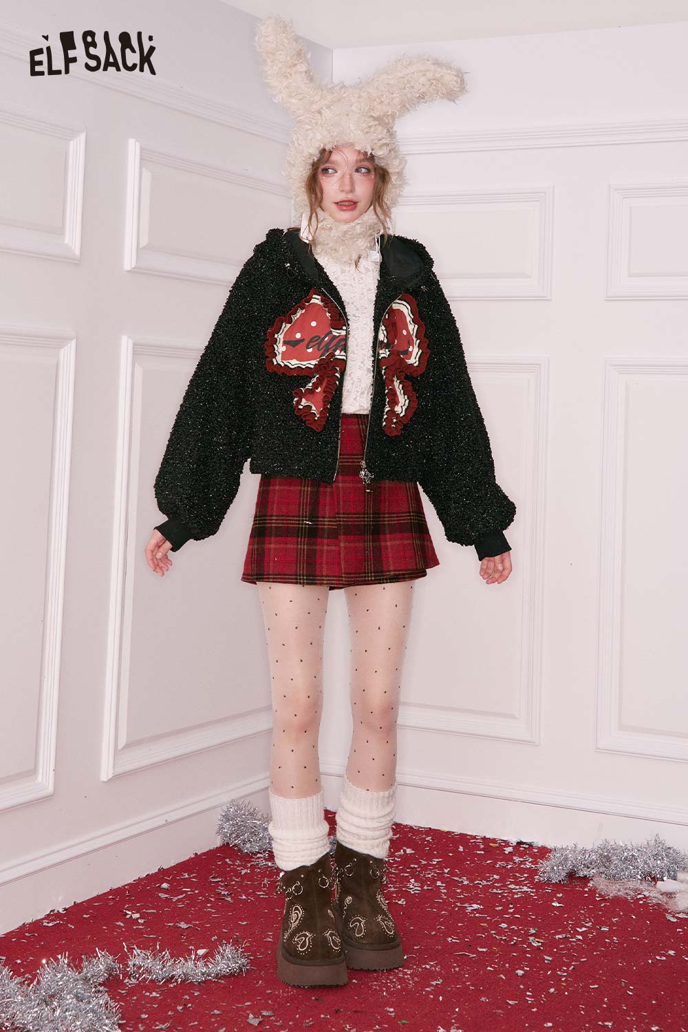 ELFSACK 3D bow glitter plush jacket in black, styled with a plaid skirt and winter accessories