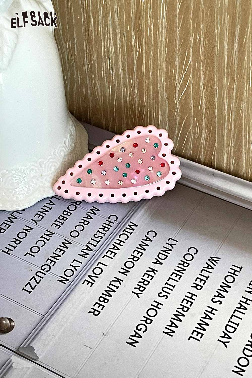 ELFSACK pink scalloped crystal embellished heart hairpin with multicolor rhinestones on a desk
