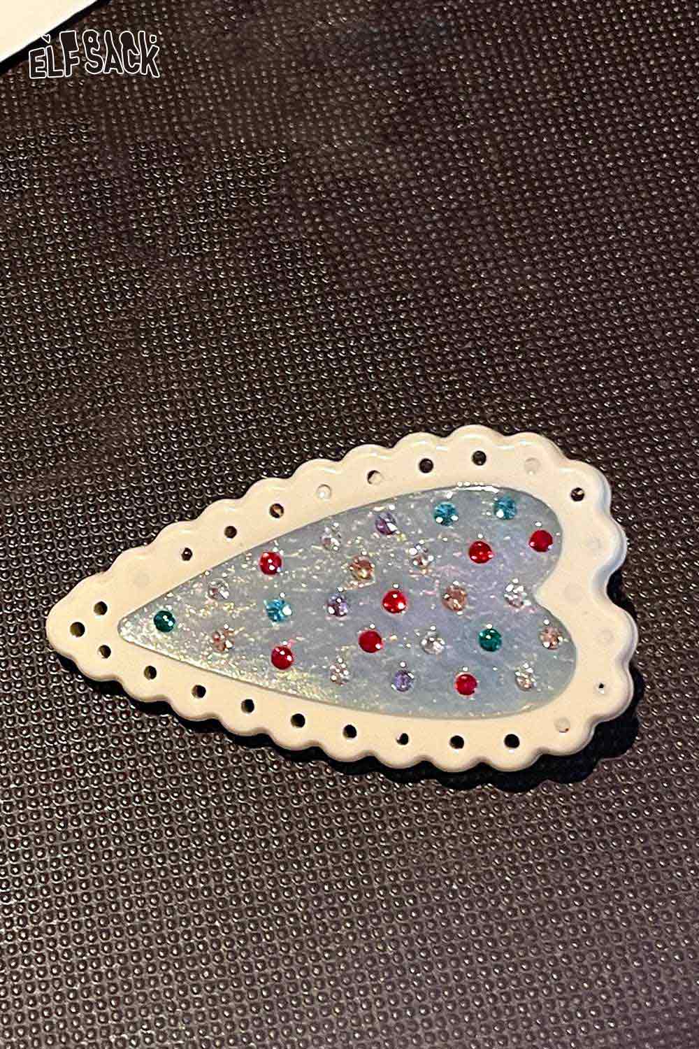 ELFSACK white scalloped crystal embellished heart hairpin with glitter blue center and multicolor rhinestones