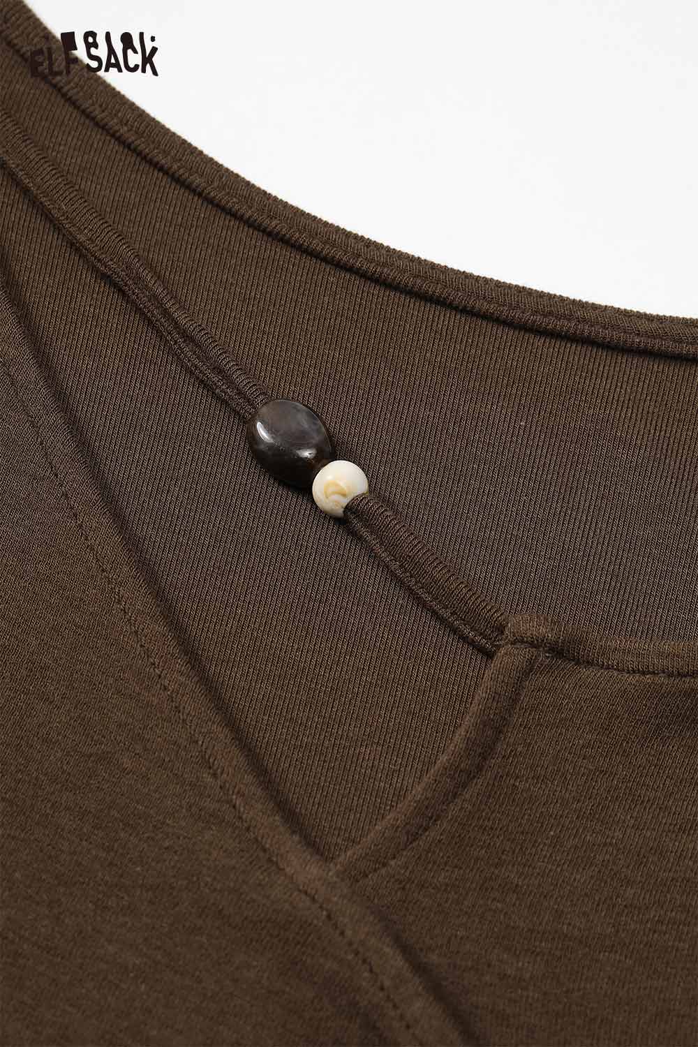 Close-up of ELFSACK asymmetric neckline midi dress showcasing unique button detail and soft fabric