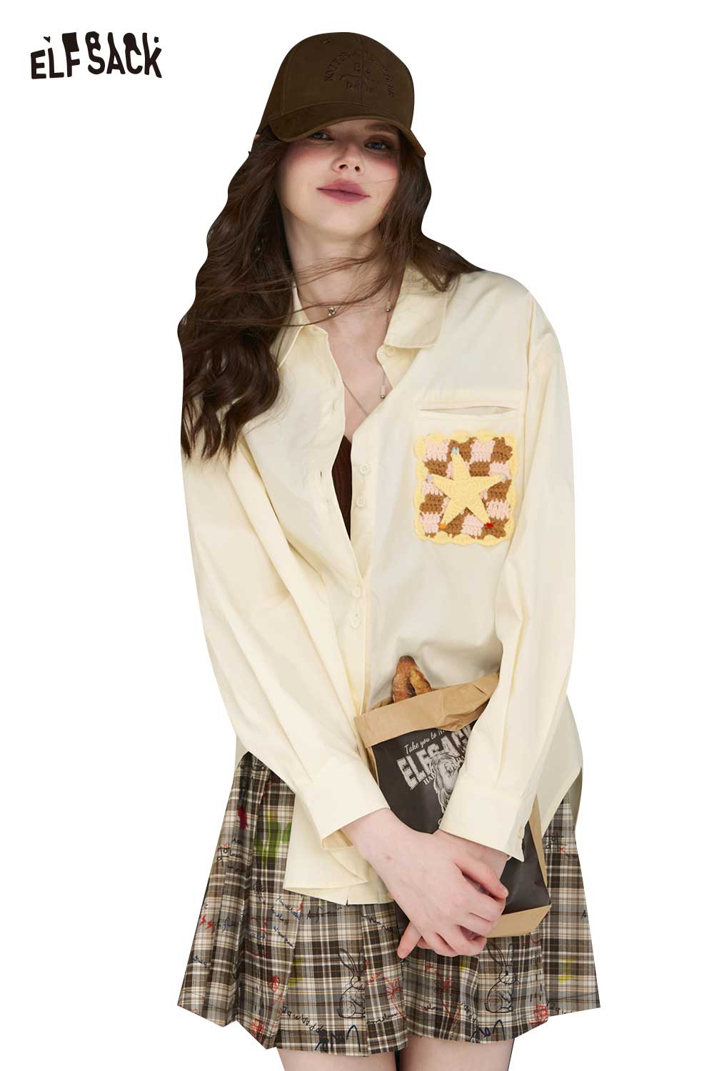ELFSACK women shirt cream button down with 3D handmade crocheted shirt pocket detail model wearing plaid skirt and brown cap