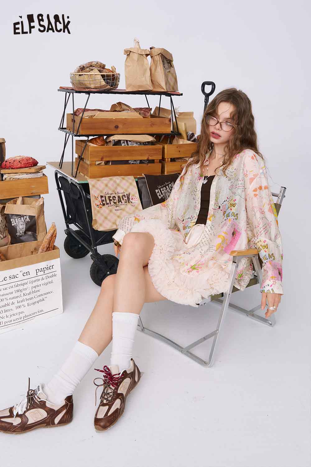 ELFSACK graffiti cartoon print shirt for women on model seated in chair wearing pastel oversized printed blouse