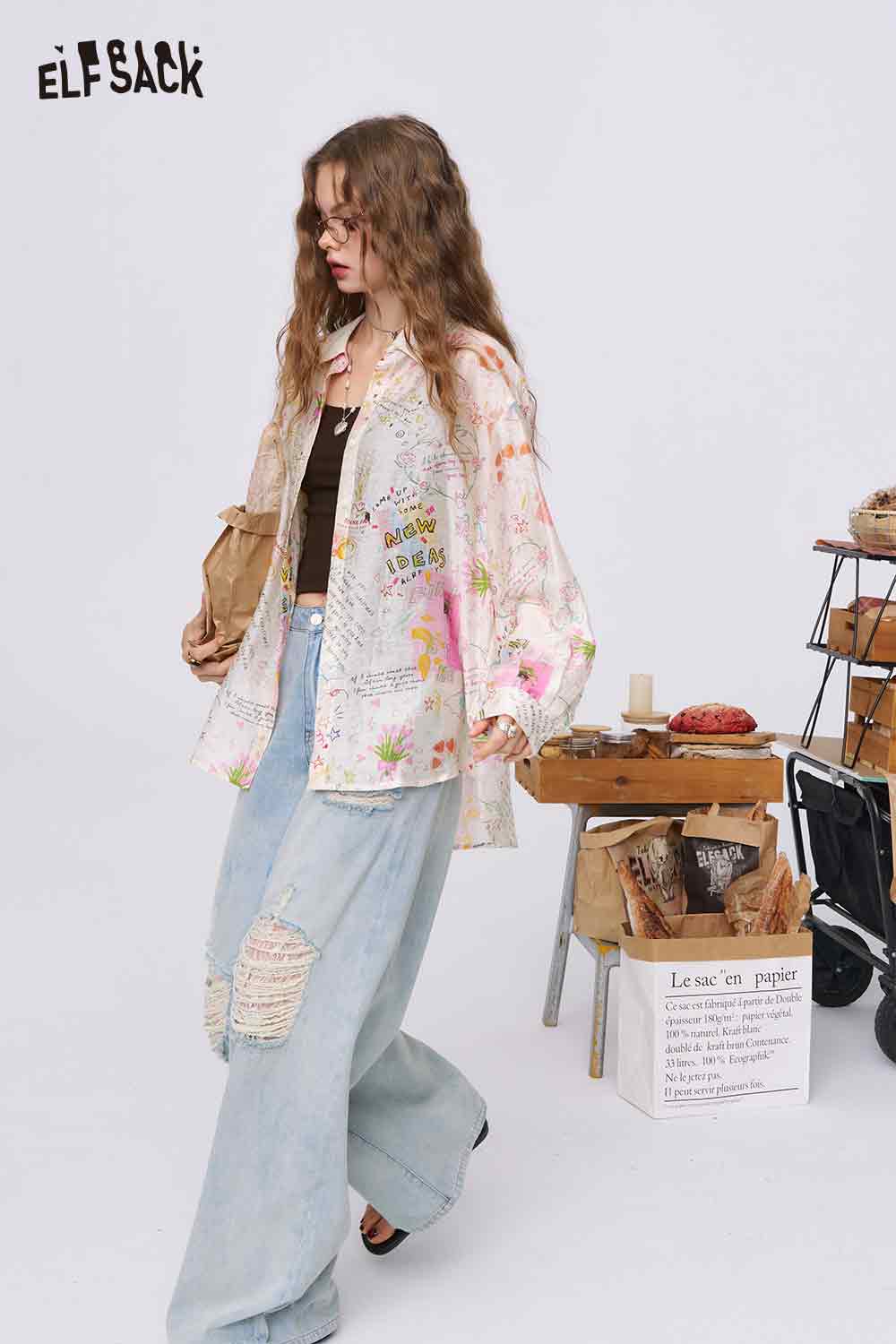 ELFSACK oversized graffiti cartoon print shirt for women on model with ripped wide leg jeans