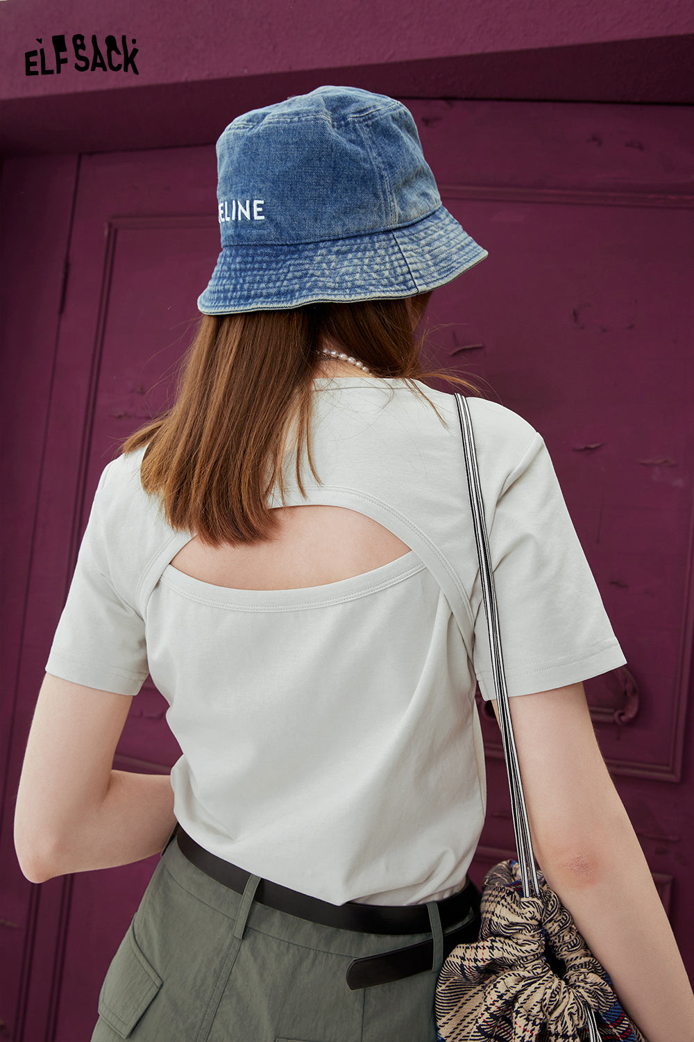 ELFSACK BM Style white T-shirt with back cutout detail worn with denim bucket hat and plaid bag