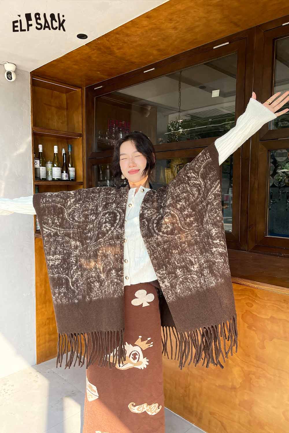 ELFSACK bohemian knit shawl with fringe displayed by a model in a stylish setting