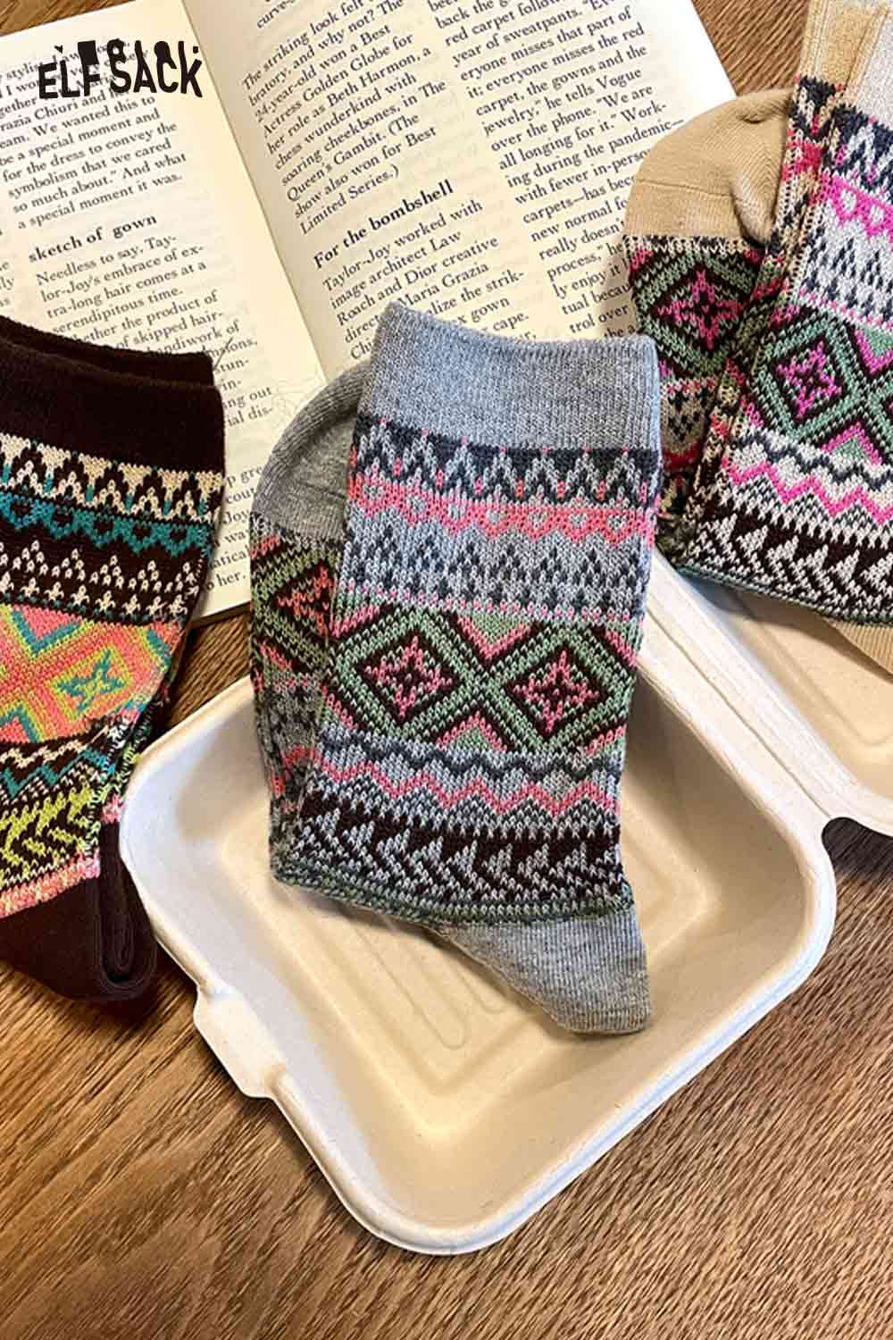 Colorful ELFSACK bohemian stripe socks for women displayed on a book and a container