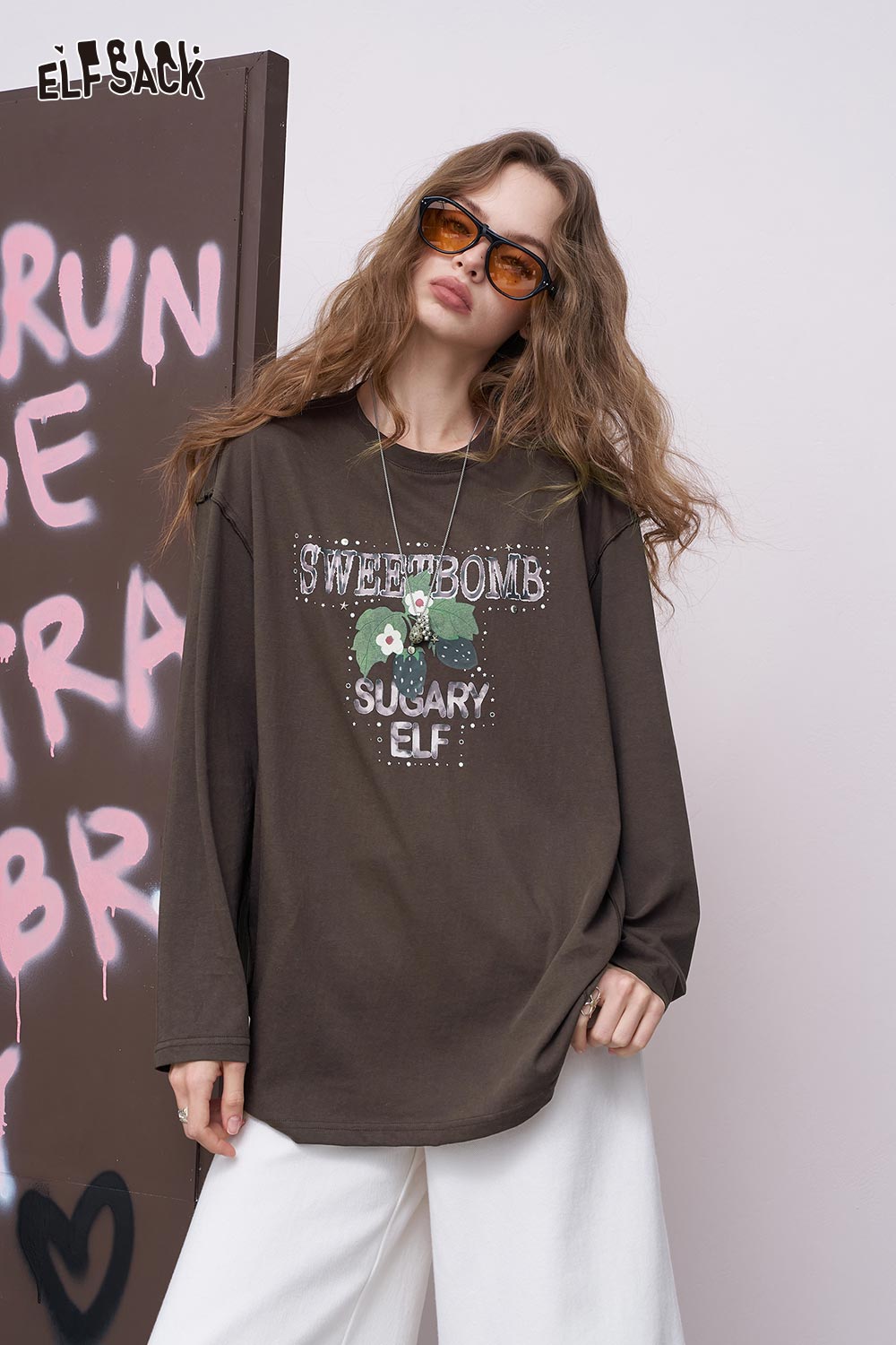 ELFSACK oversized daisy graphic tee for women long sleeve brown relaxed fit on model wearing sunglasses