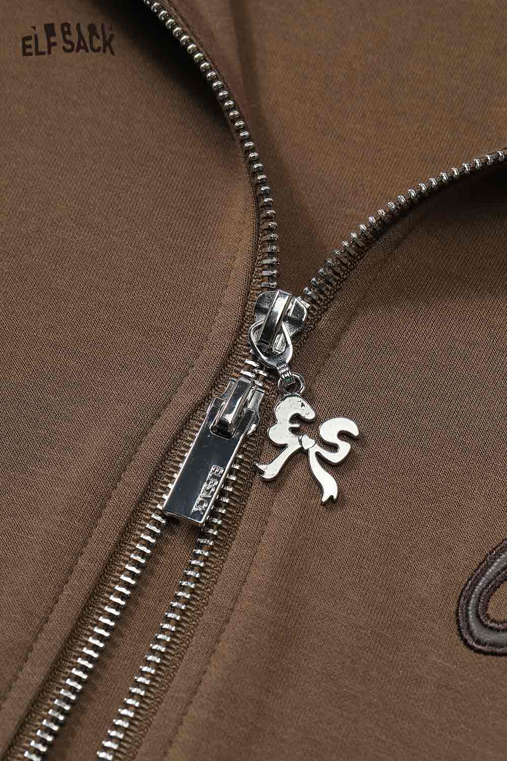 Close-up of ELFSACK brushed French terry zip up hoodie featuring a silver zipper and logo charm