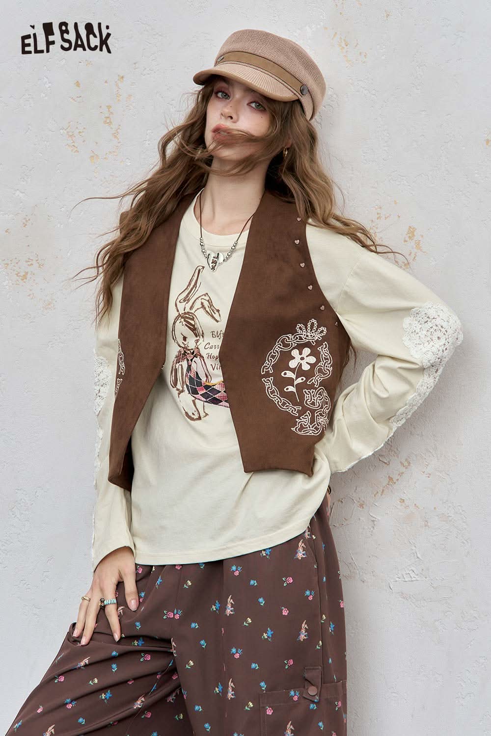 ELFSACK bunny graphic tee for women styled with a brown vest and patterned pants
