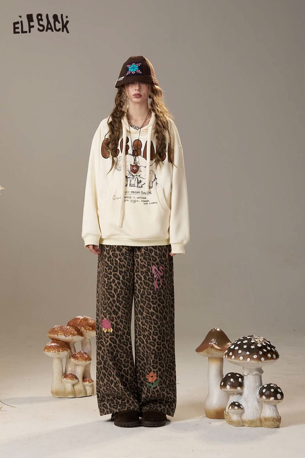 ELFSACK cartoon elephant hooded sweatshirt styled with patterned pants in a whimsical setting