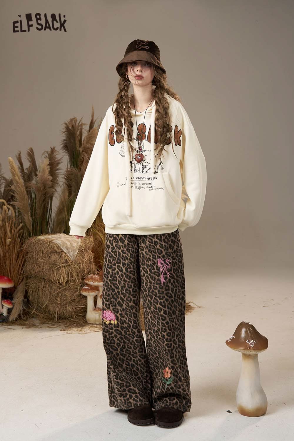 ELFSACK cartoon elephant hooded sweatshirt in cream color, paired with leopard print pants for a stylish look.