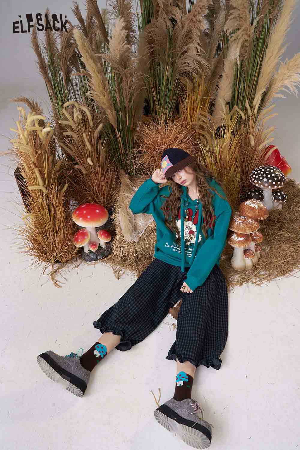 ELFSACK cartoon elephant hooded sweatshirt in teal, styled with black wide-leg pants and accessories