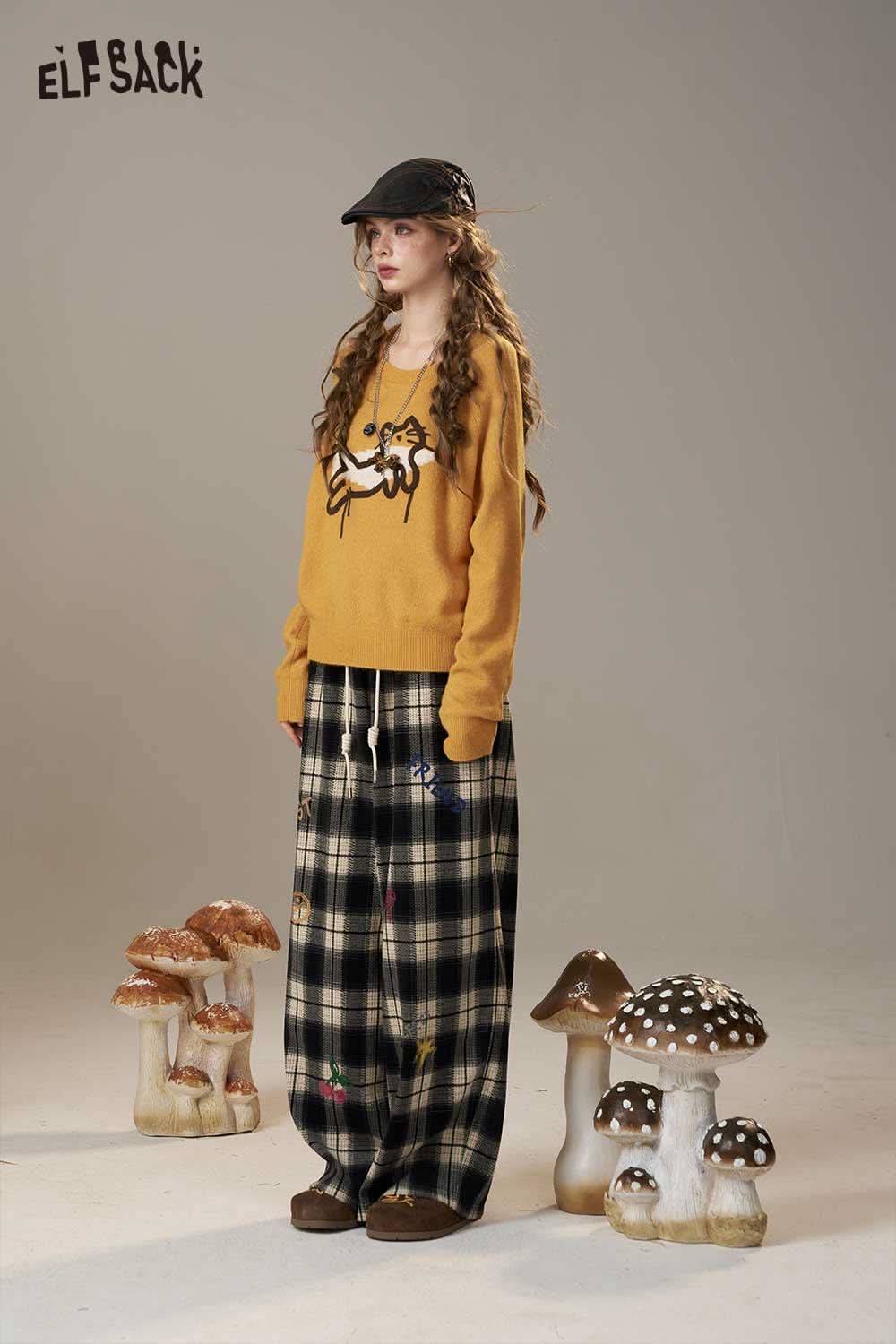 ELFSACK cartoon embroidery sweater in mustard yellow worn with plaid wide-leg pants