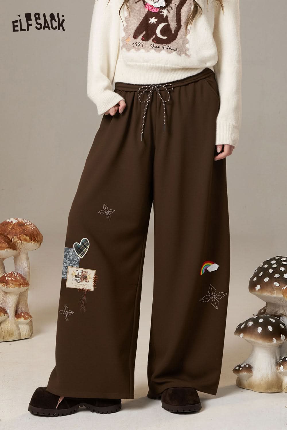 ELFSACK cartoon embroidery sweatpants for women in brown with playful designs and comfortable fit