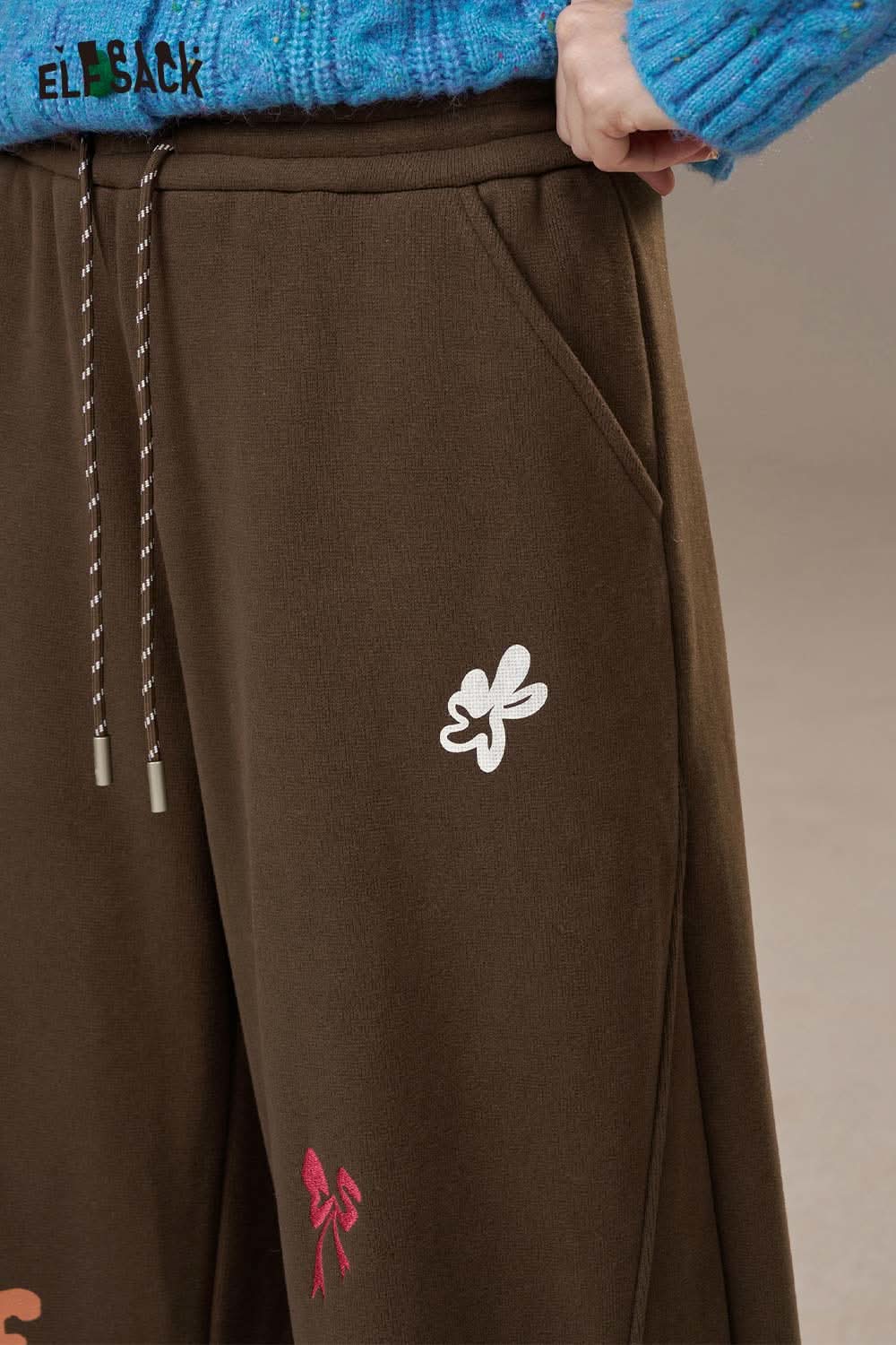 Brown ELFSACK cartoon embroidery sweatpants for women featuring colorful accents and pockets