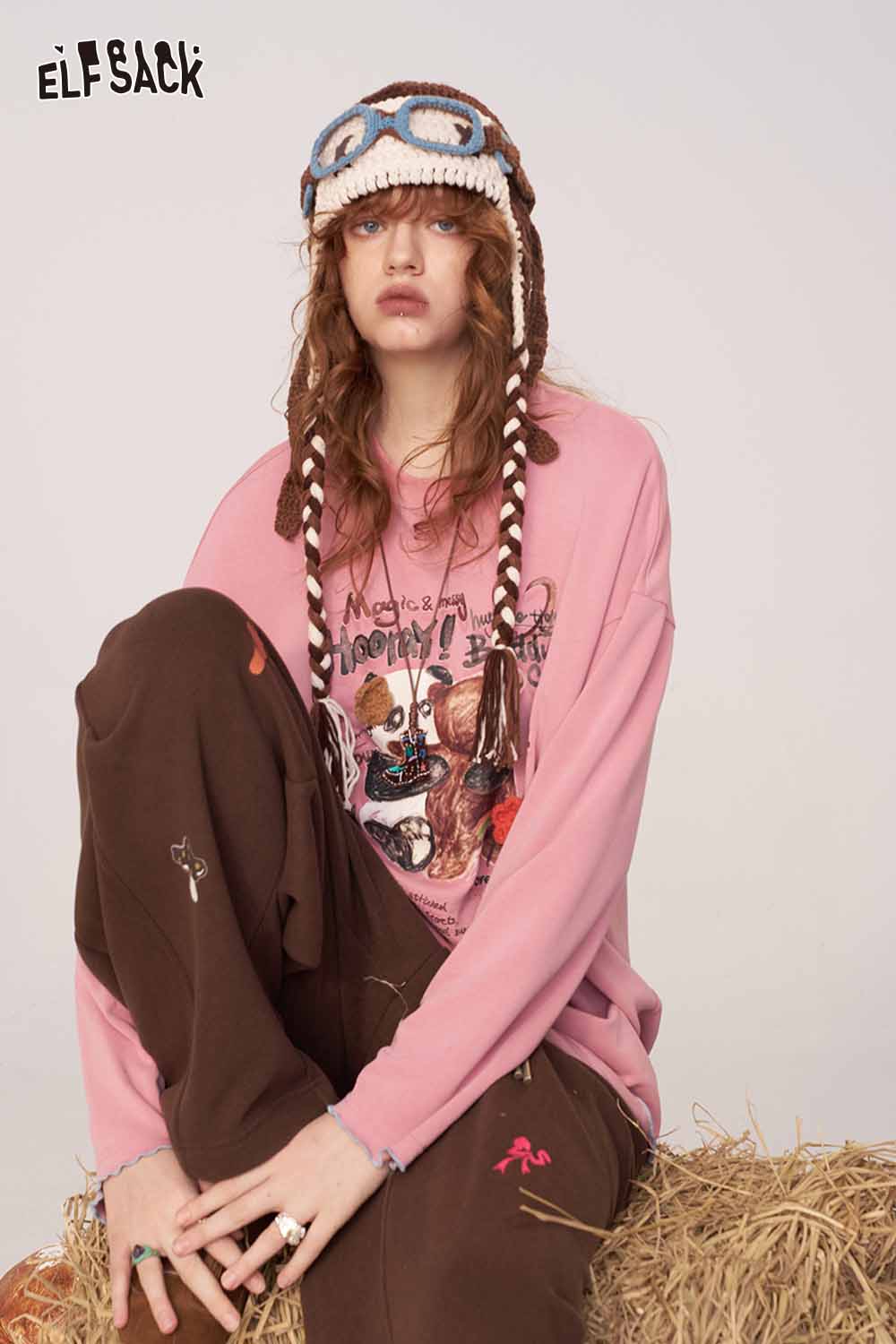 ELFSACK cartoon print long sleeve tee in pink worn by a model with stylish accessories