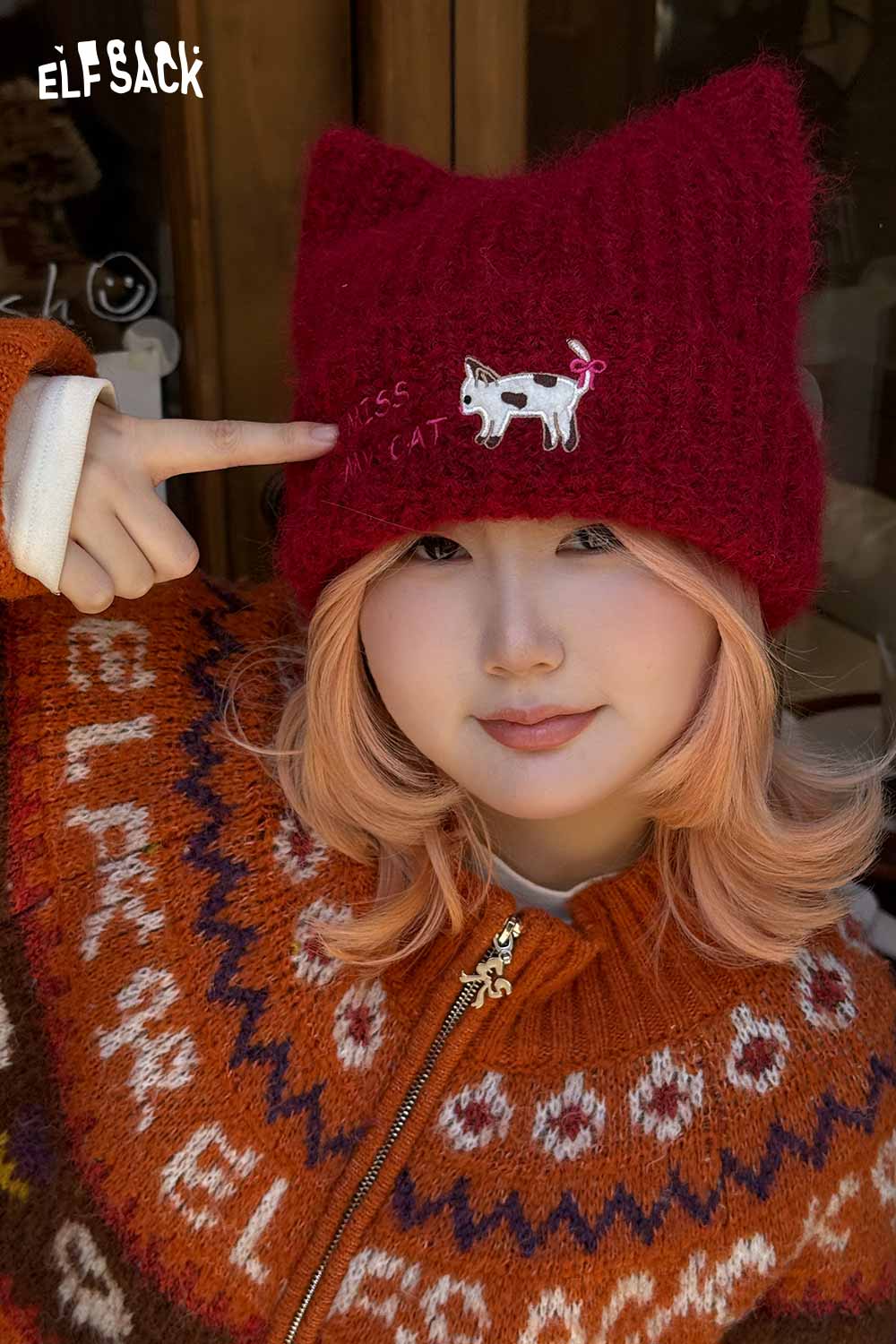 
                  
                    ELFSACK cat ear beanie for women in red, featuring a playful cow design on a cozy knitted hat
                  
                