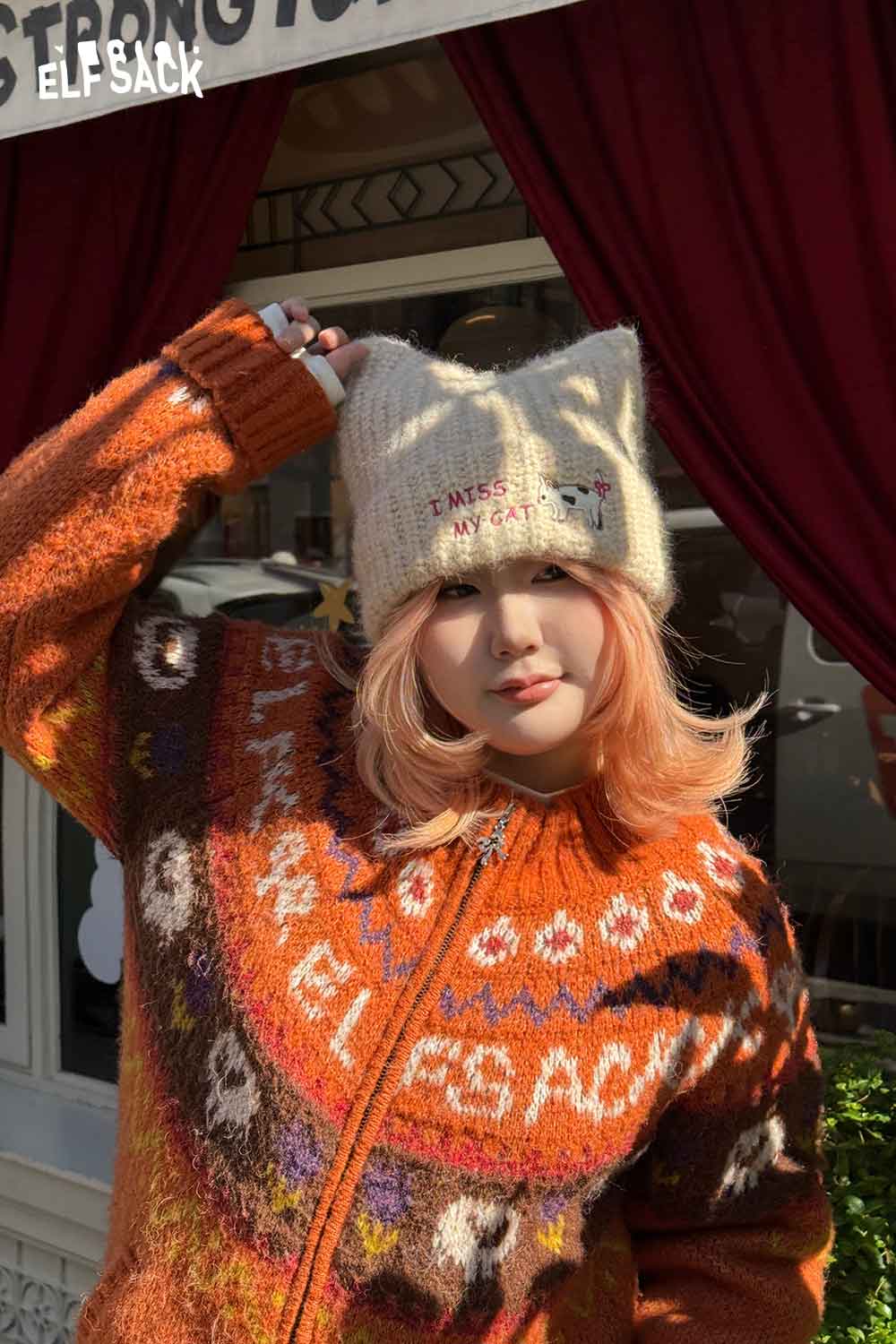 
                  
                    Stylish cat ear beanie for women featuring a playful design, worn with a colorful sweater
                  
                