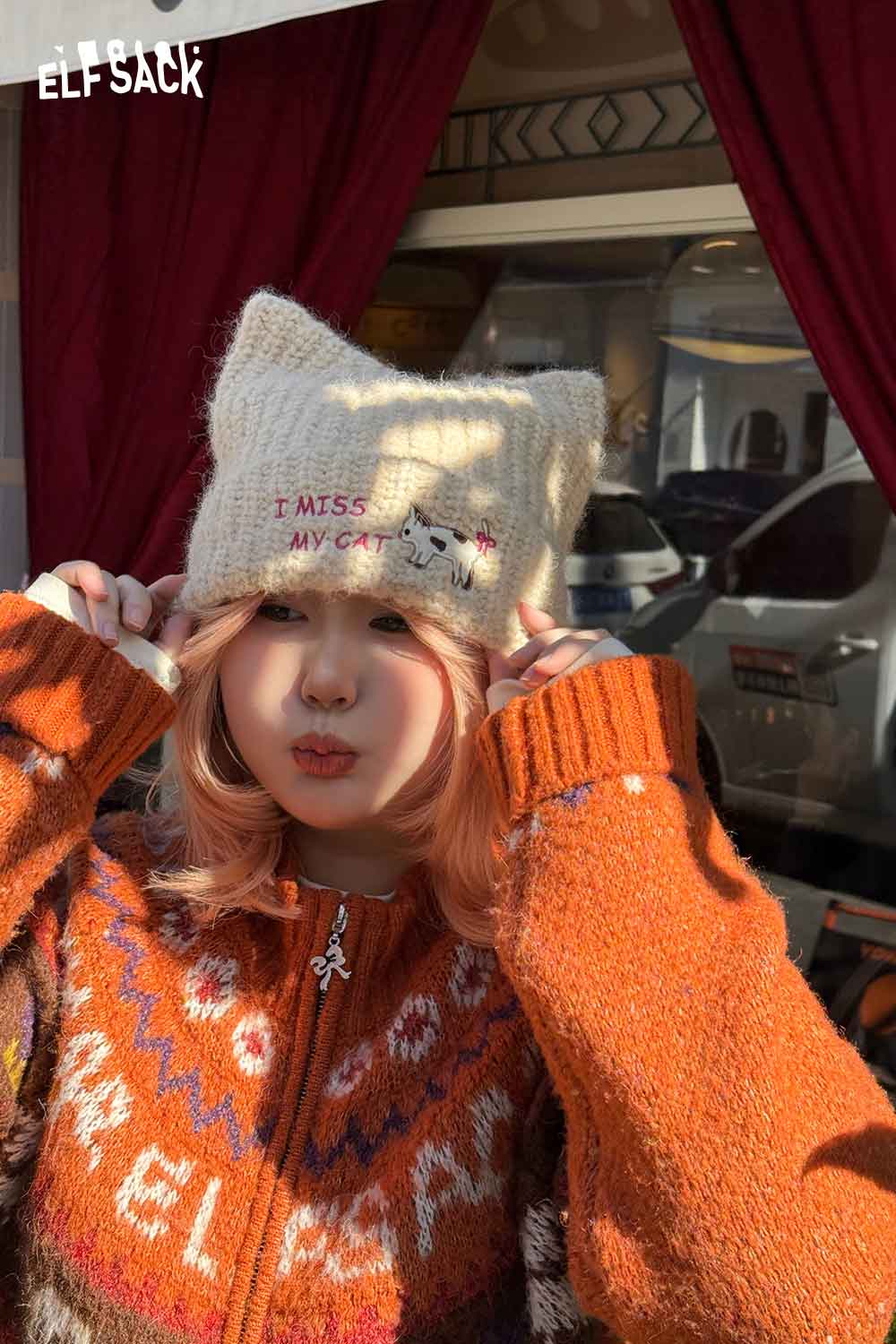 
                  
                    Cozy cream cat ear beanie for women from ELFSACK, featuring playful embroidery and a warm knit design.
                  
                