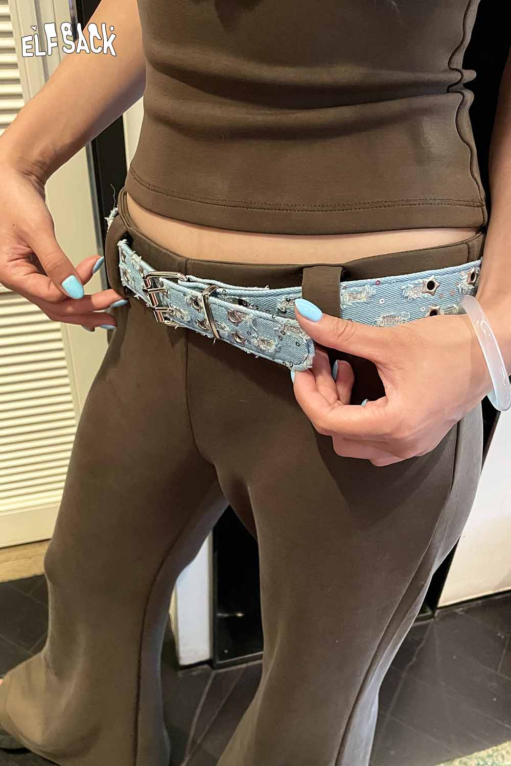 ELFSACK celestial motif leather belt for women styled with fitted top and wide-leg pants