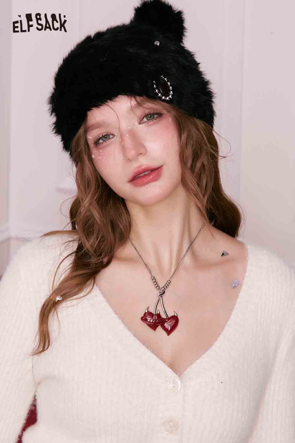ELFSACK cherry pendant heart necklace worn by a model with a cozy white cardigan and black furry hat