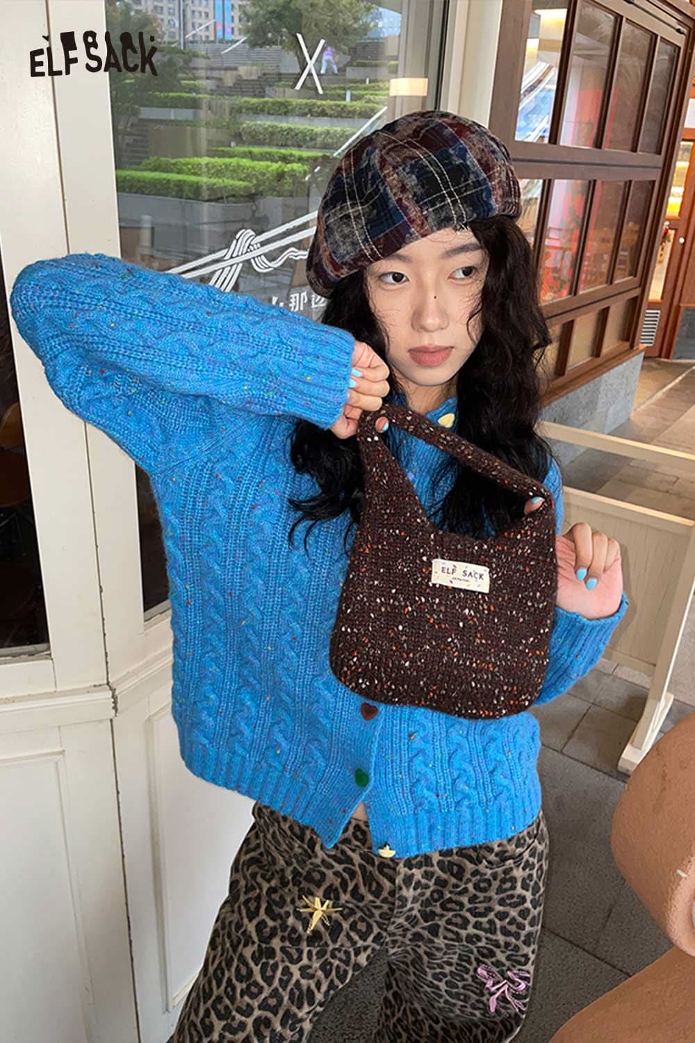 ELFSACK color blocked knitted beret worn by a model with a blue sweater and stylish bag