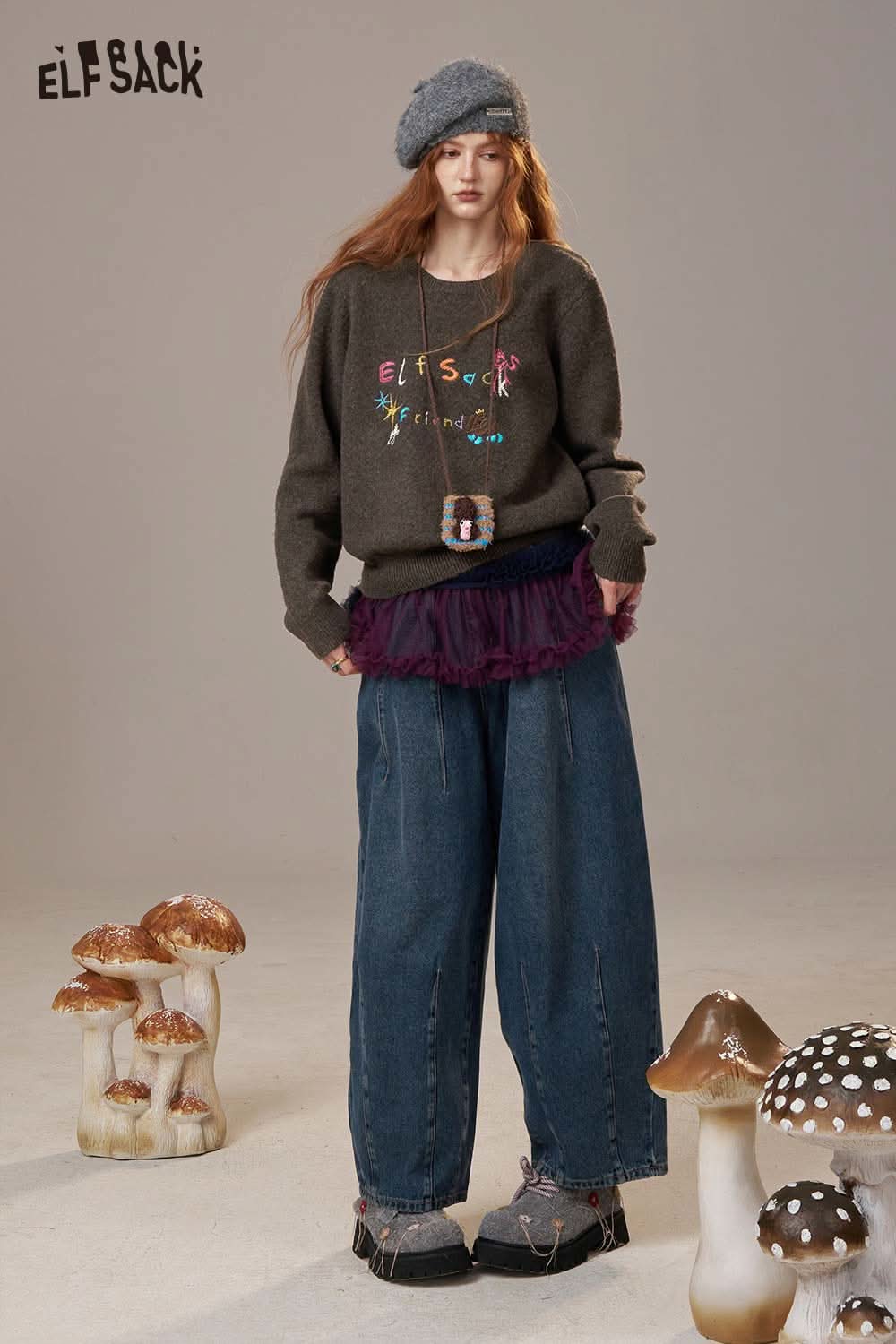 Woman wearing a colorful logo embroidery sweater from ELFSACK paired with loose jeans and a beret