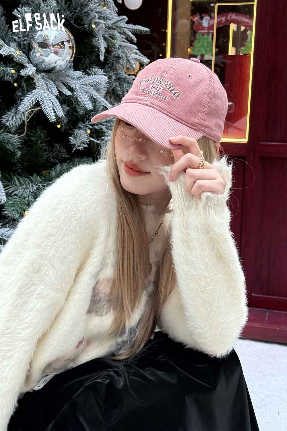 Fashionable pink corduroy baseball cap for women styled with a cozy sweater in a festive setting