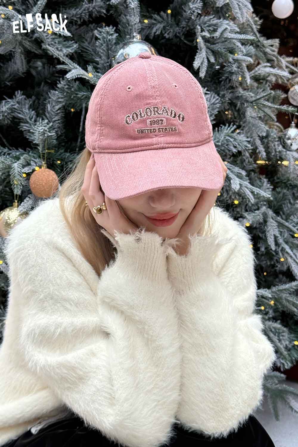 Woman wearing a pink corduroy baseball cap for women with Colorado embroidery, styled with a cozy sweater