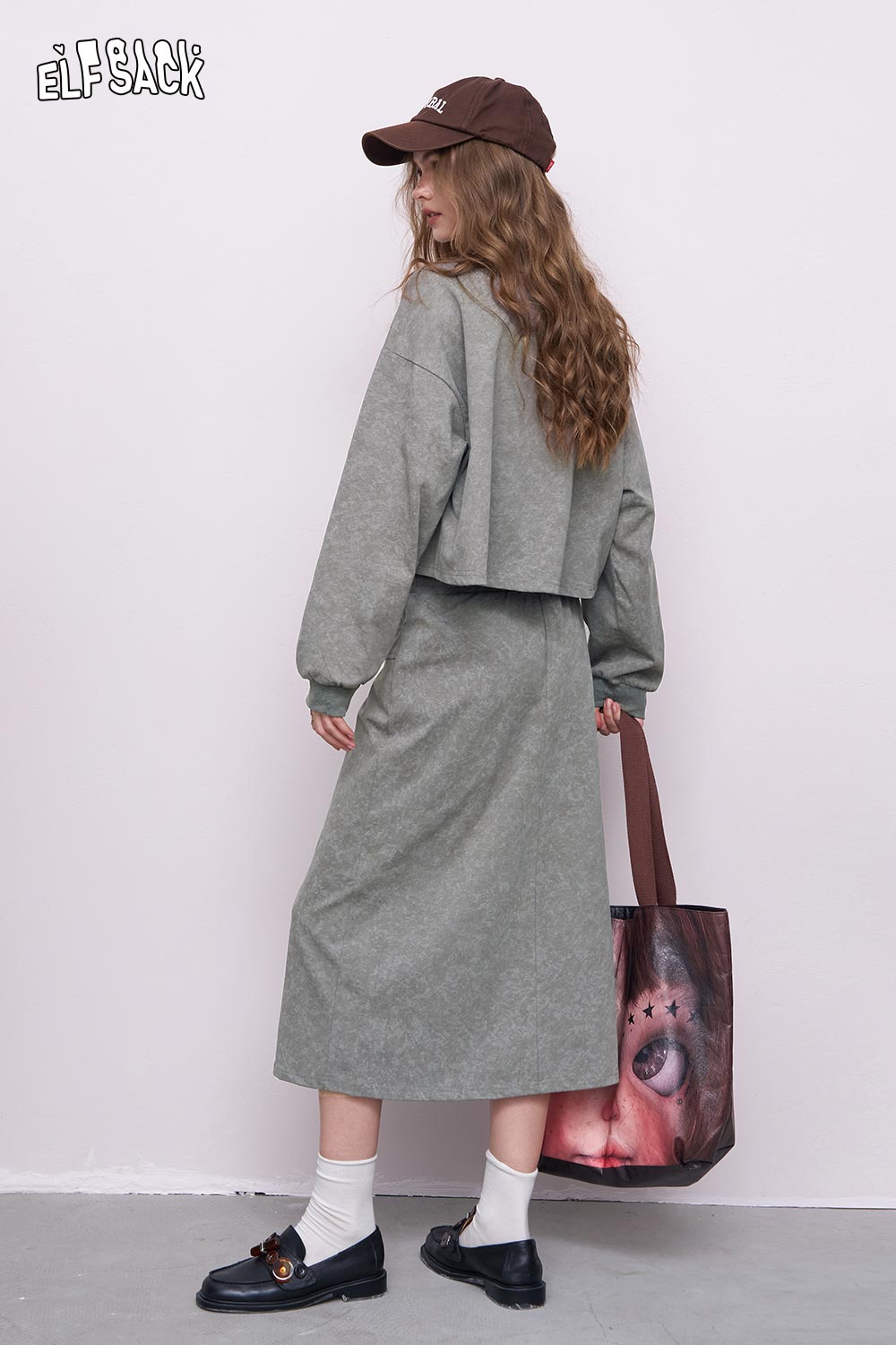 ELFSACK gray embroidered hoodie dress set on model back view with brown cap printed tote bag and loafers