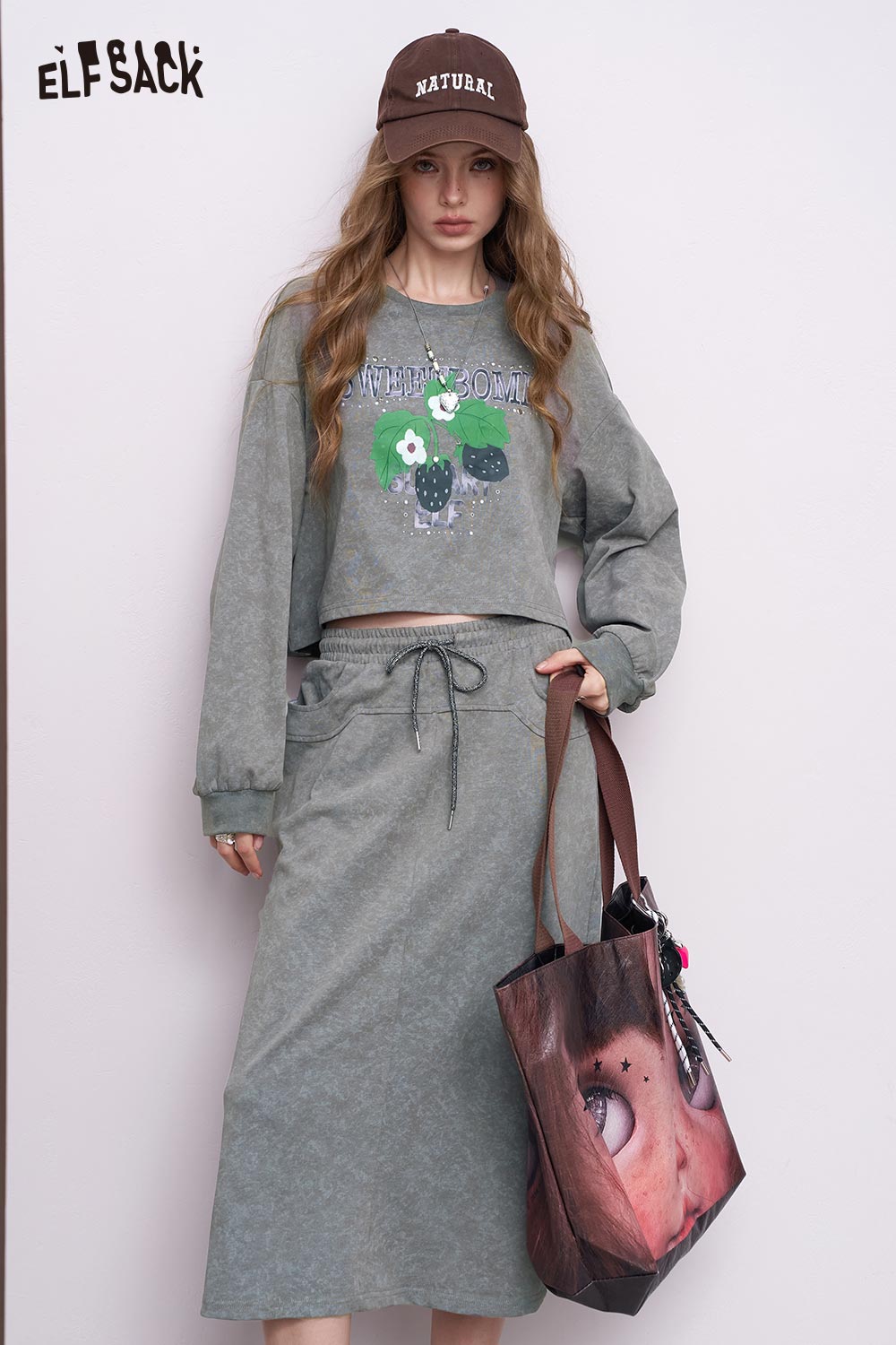 ELFSACK model wearing gray embroidered hoodie dress set with cropped floral sweatshirt and drawstring midi skirt