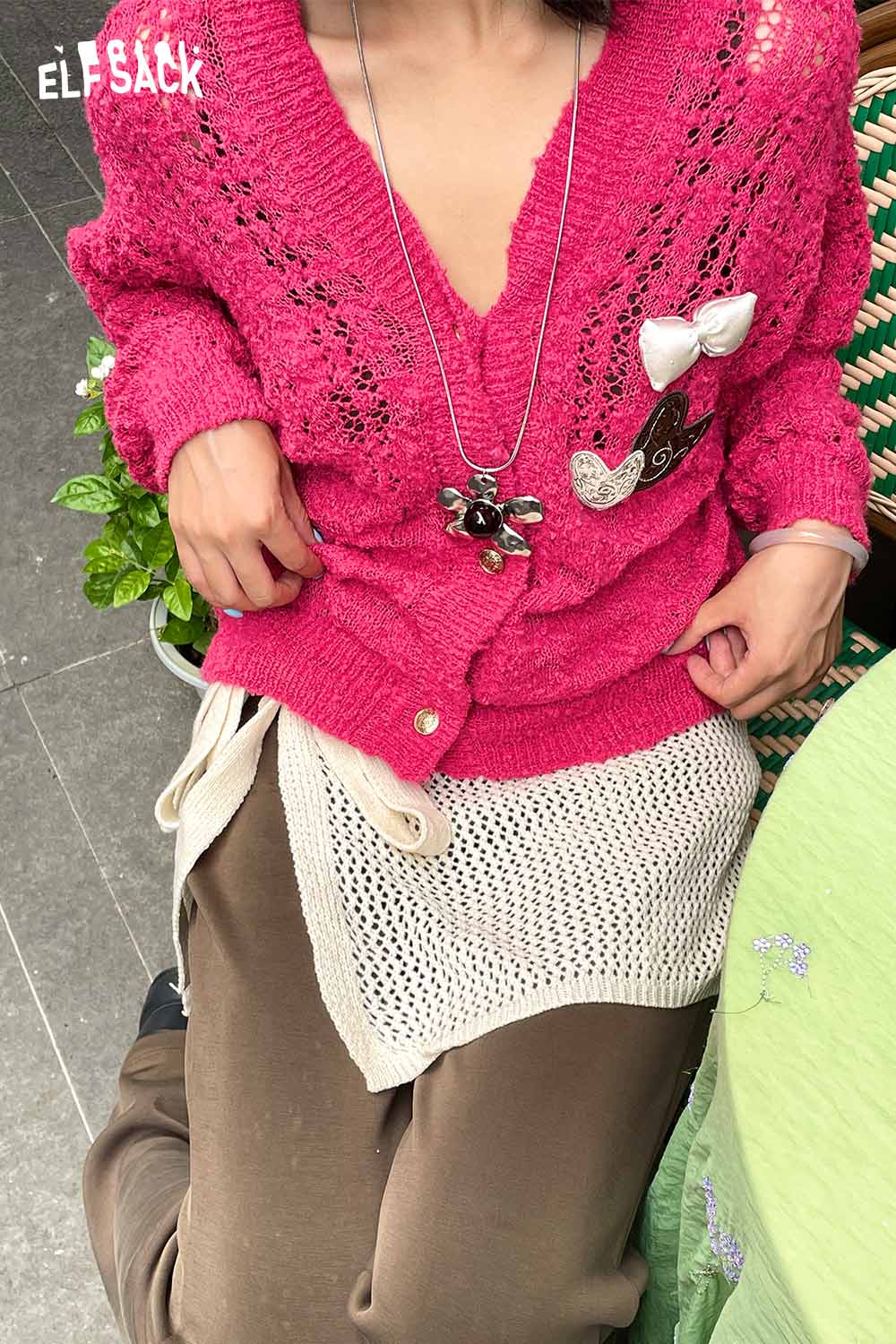 Model wearing a pink sweater over a cotton blend knit skirt with apron, ideal for casual style