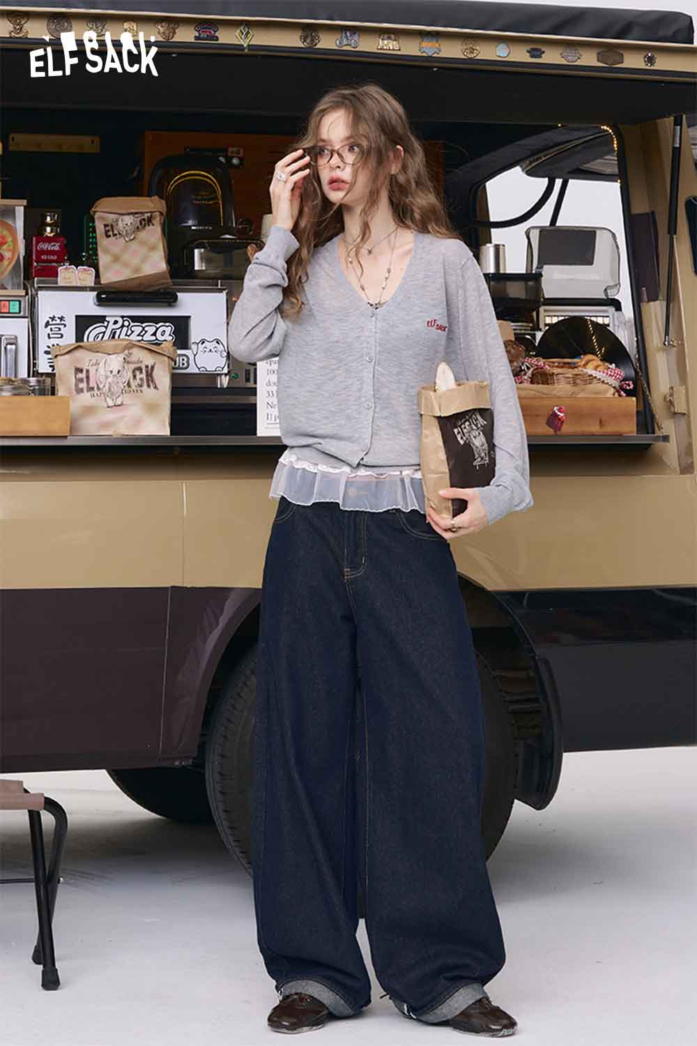 ELFSACK model wearing vintage straight leg jeans for women in dark denim with gray cardigan and tote
